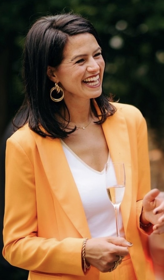Sofie lachend in een oranje blazer